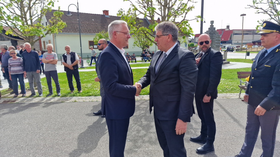 Minister za notranje zadeve Boštjan Poklukar se rokuje z županom Središča ob Dravi Tonijem Jelovico, v ozadju stojijo ljudje