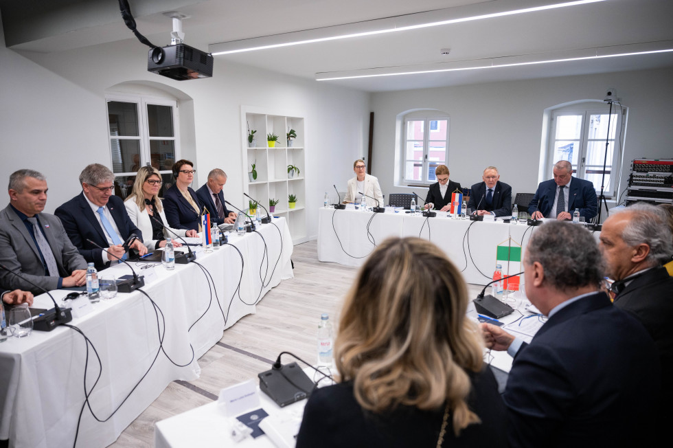 Delegacije Slovenije, Hrvaške in Italije sedijo za belimi mizami, ki so postavljene v obliko trikotnika, pred sabo imajo mikrofone.