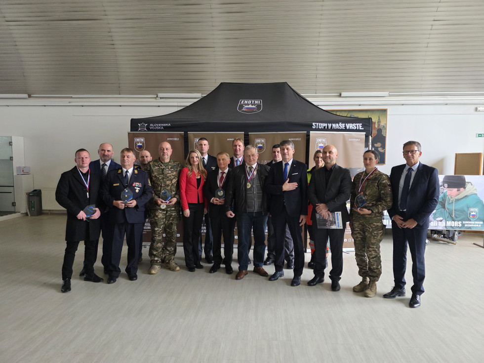 Prejemniki priznanj in visoki gosti stojijo drug ob drugem v dveh vrstah in se fotografirajo