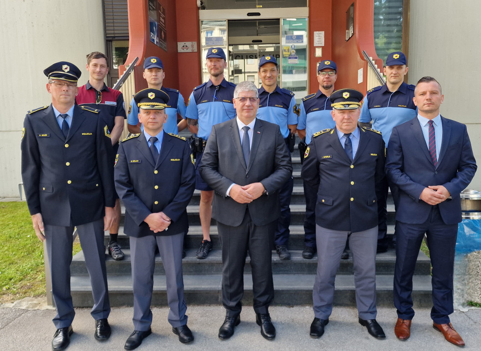 Udeleženci sestanka stojijo pred zgradbo policijske uprave Celje in se slikajo.