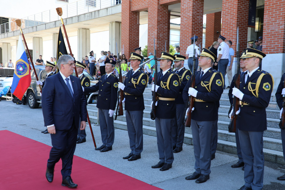 Minister hodi po rdeči preprogi, ob preprogi stojijo pripadniki častne čete
