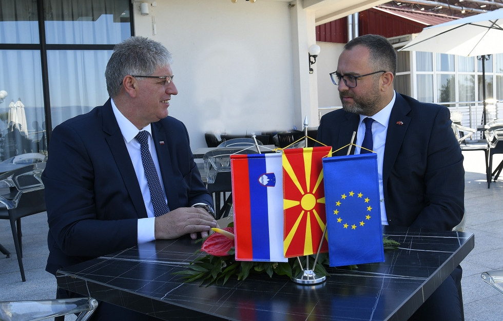 Ministra sedita in se pogovarjata, pred njima na mizi slovenska, makedonska in evropska zastava