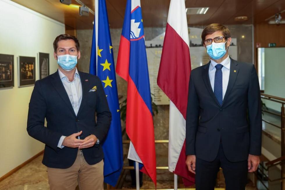 Minister in sogovornik pred zastavami