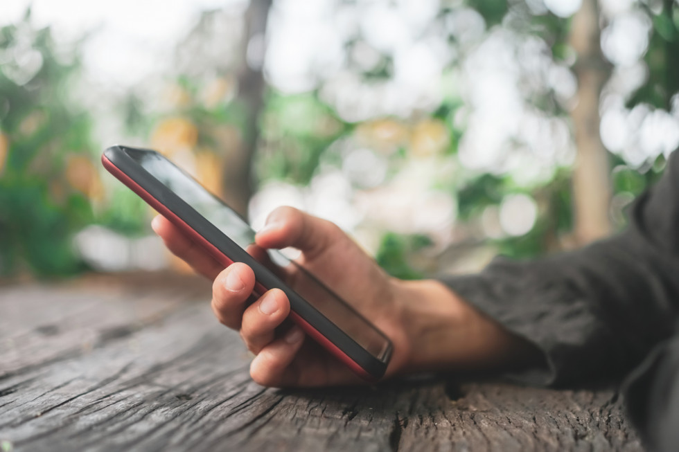 Oseba tipka po mobilnem telefonu.