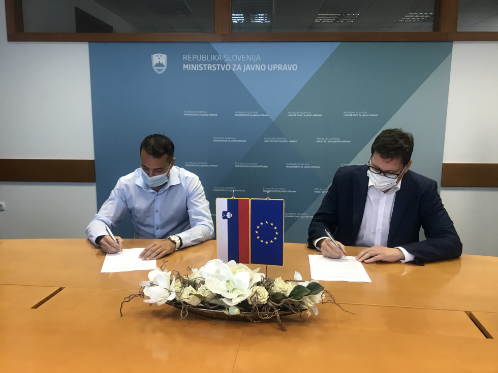 podpisnika sedita za mizo in podpisujeta pogodbo