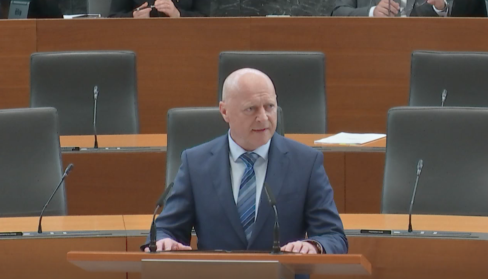 minister standing at the speaker desk