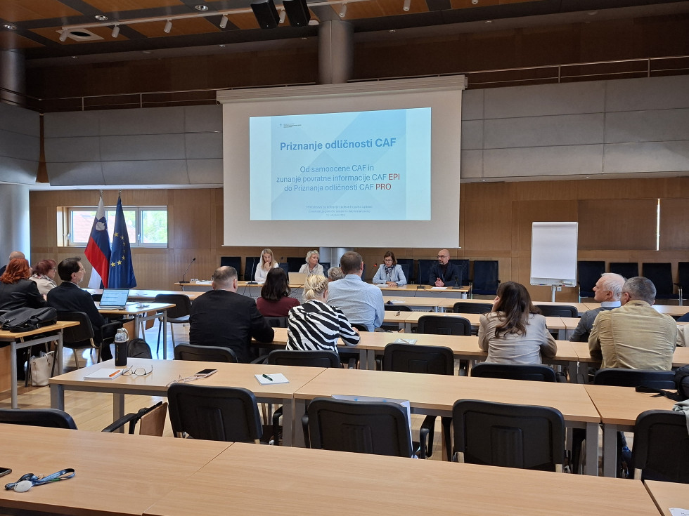 Udeleženci v dvorani poslušajo predstavitve o Priznaju odličnosti CAF