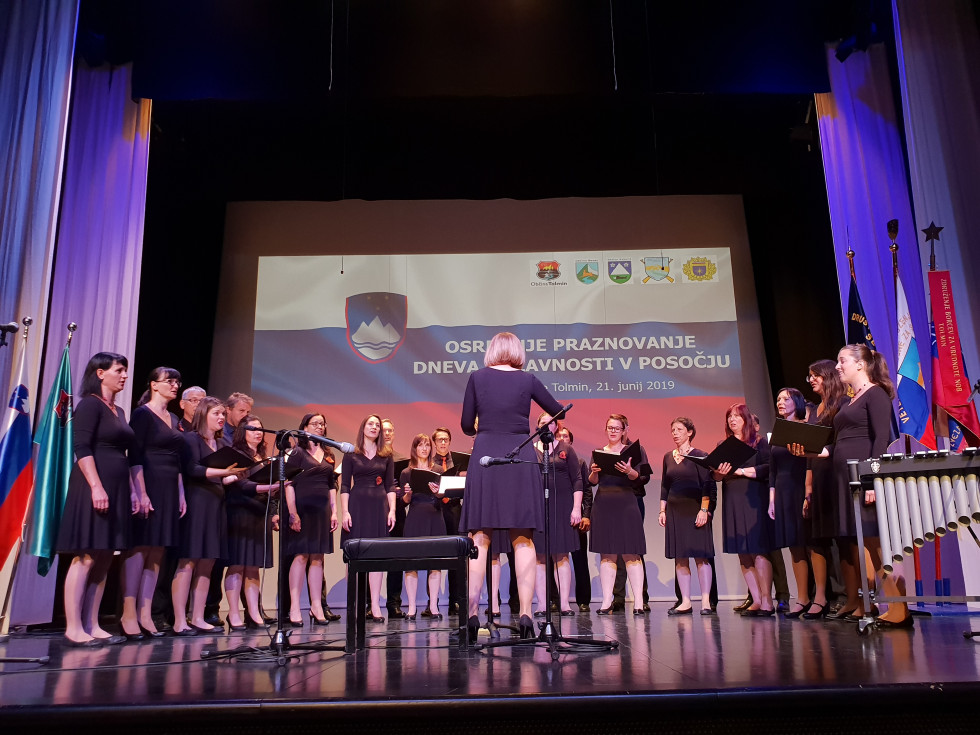 Pevski zbor za odru, spredaj dirigentka.