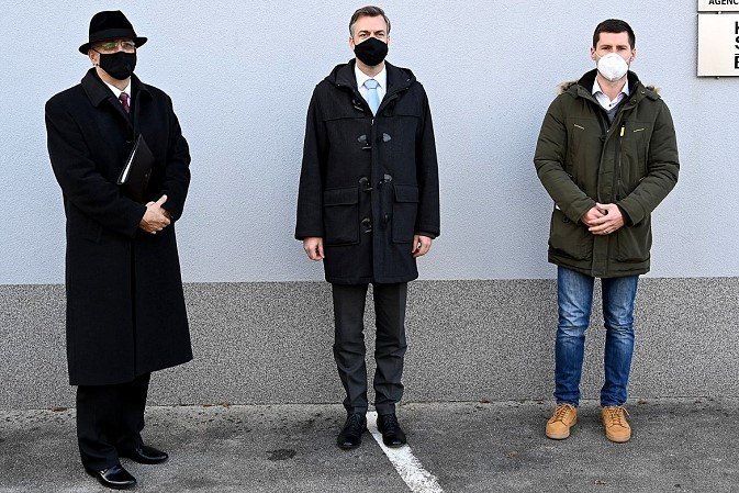 Državni sekretar dr. Anton Olaj, župan Mestne občine Novo mesto Gregor Macedoni in predstavnik Krajevne skupnosti Bučna vas Matic Vidic stojijo pred stavbo krajevne skupnosti.