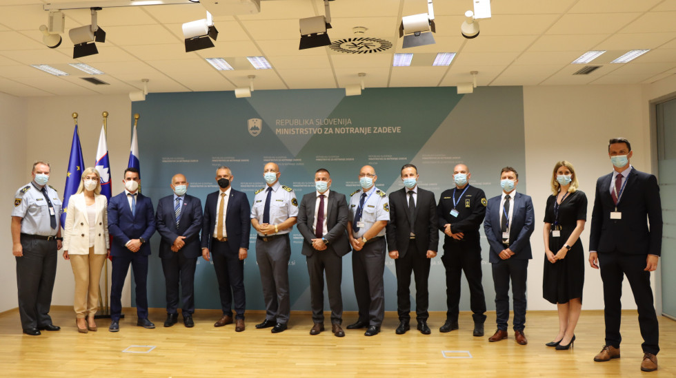 Skupinska slika slovenske in črnogorske delegacije pred panojem z napisom Ministrstvo za notranje zadeve