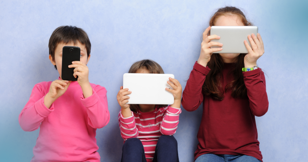Trije otroci uporabljajo mobilni telefon in tablici