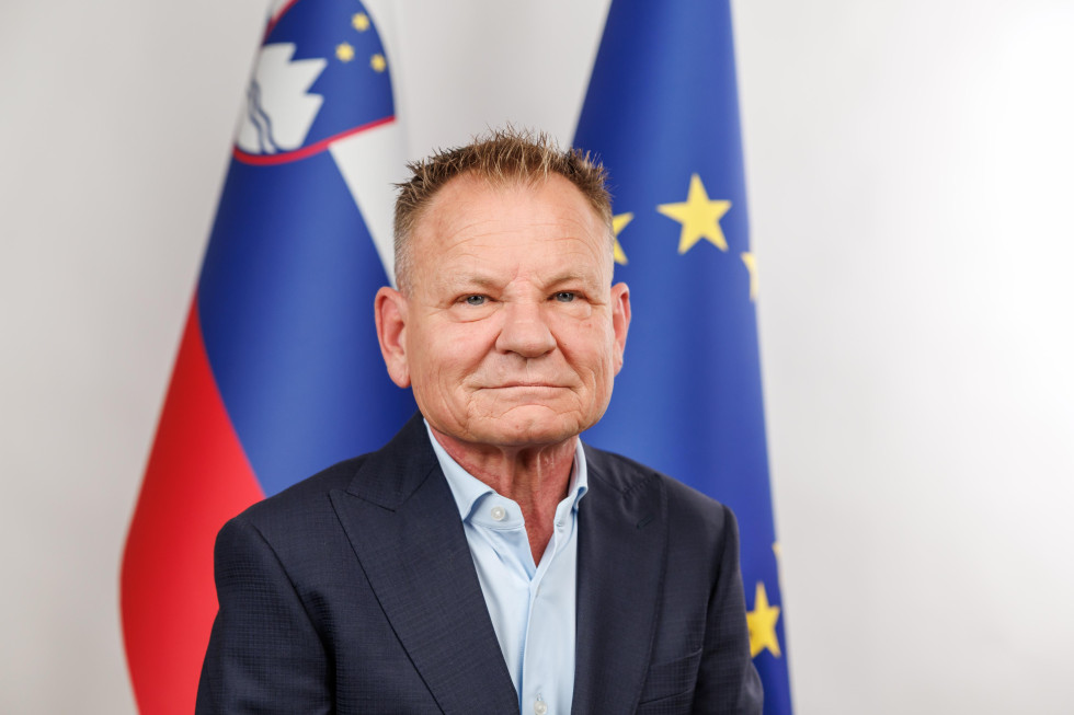 Portret ministra pred zastavama Slovenije in Evropske unije.