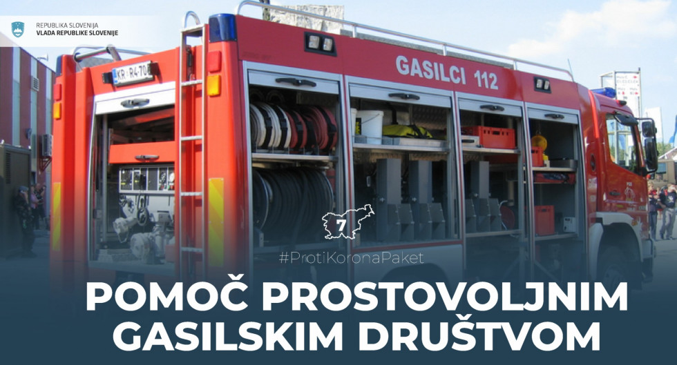Gasilsko vozilo in napis o pomoči vlade prostovoljnim gasilskim društvom