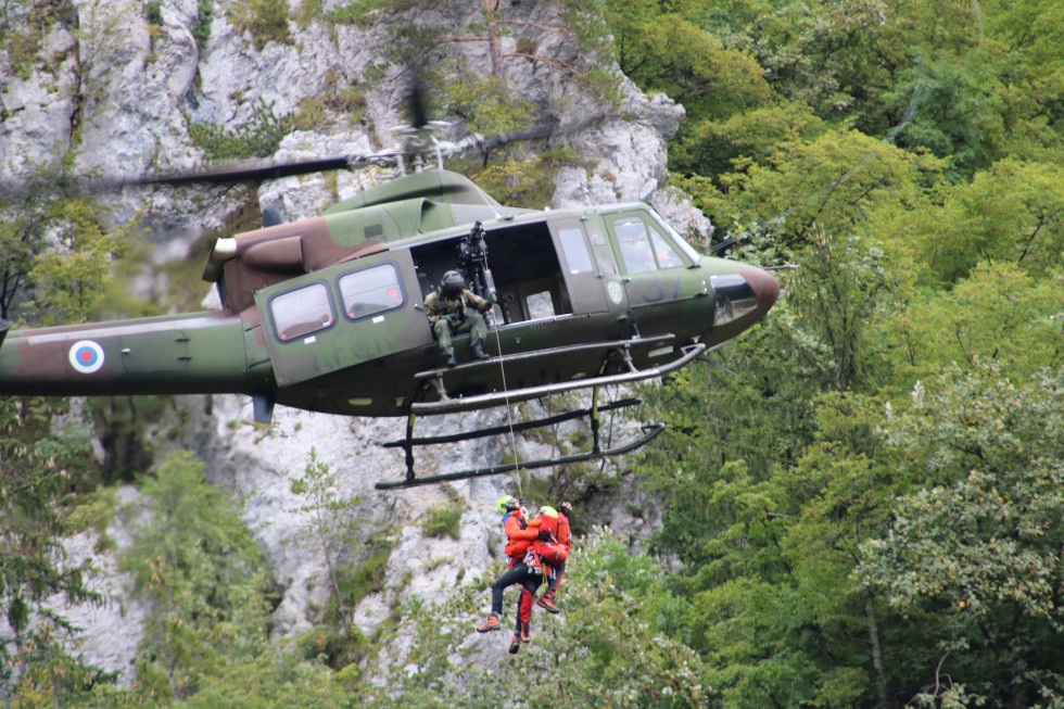 Helikopter Slovenske vojske Bell 412 med reševanjem lebdi in z vitlom dviga ponesrečenca