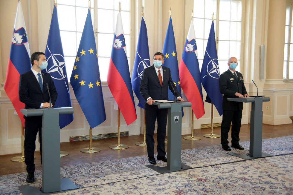 Matej Tonin, Borut Pahor in Robert Glavaš stojijo vsak za svojo govornico v predsedniški palači, v ozadju zastave NATO, EU in Slovenije
