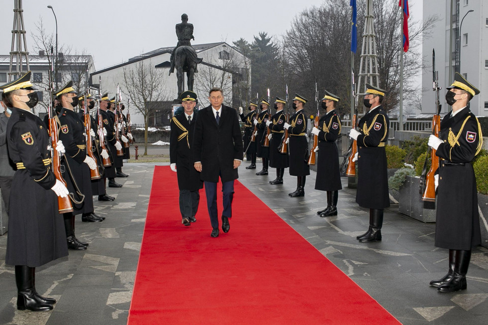 Predsednik s pribočnikom hodi po rdeči preprogi med kordonoma gardistov