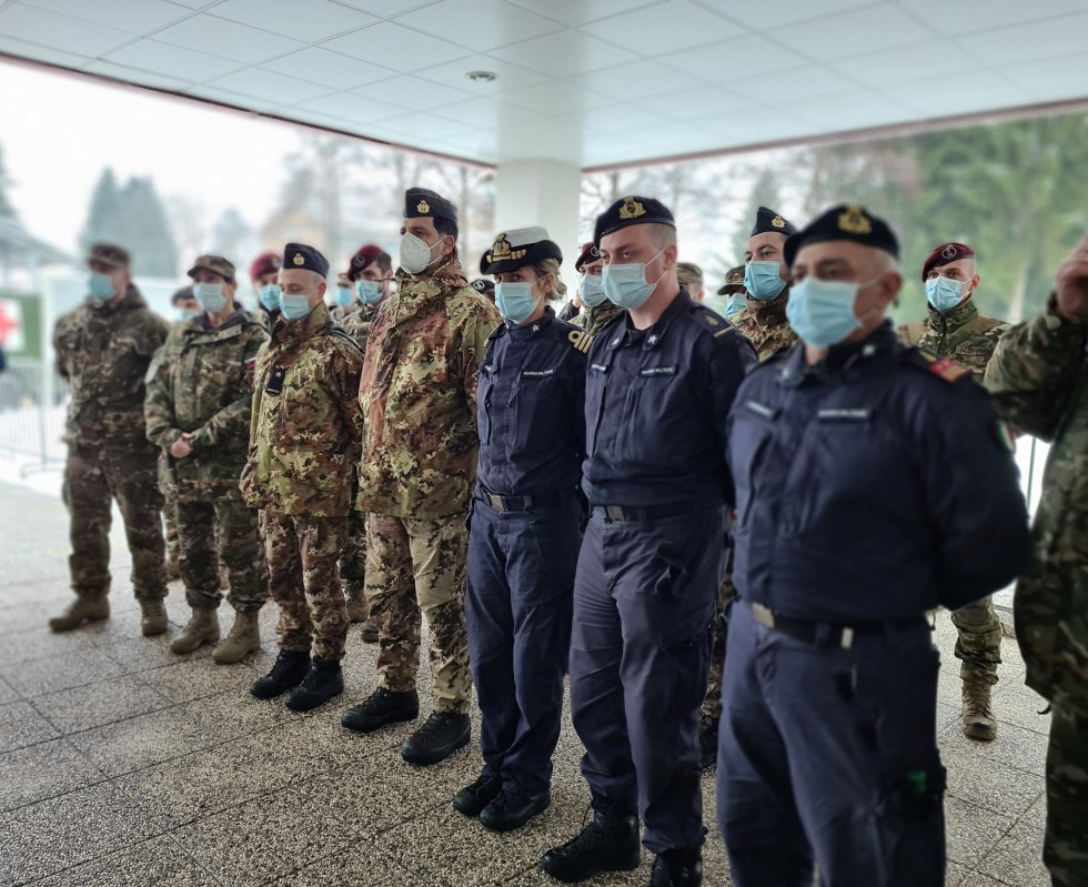 Italijanski zdravstveni delavci stojijo v vrsti po prihodu v vojašnico.