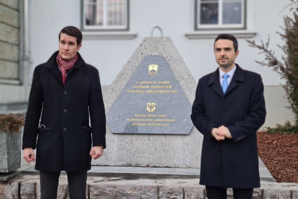 Podžupan in minister stojita pred spominskim obeležjem.