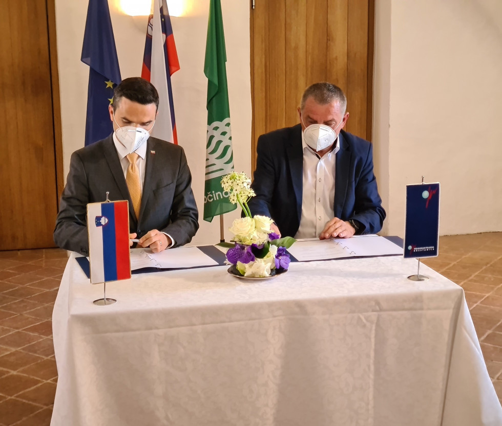 Minister za obrambo mag. Matej Tonin in direktor Termoelektrarne Brestanica Tomislav Malgaj sedita za podpisno mizo in podpisujeta sporazum