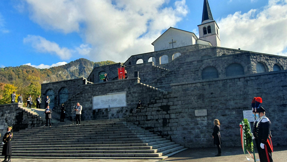 Spomenik italijanskim vojakom. Do njega vodijo široke stopnice. V ozadju je velika cerkev.