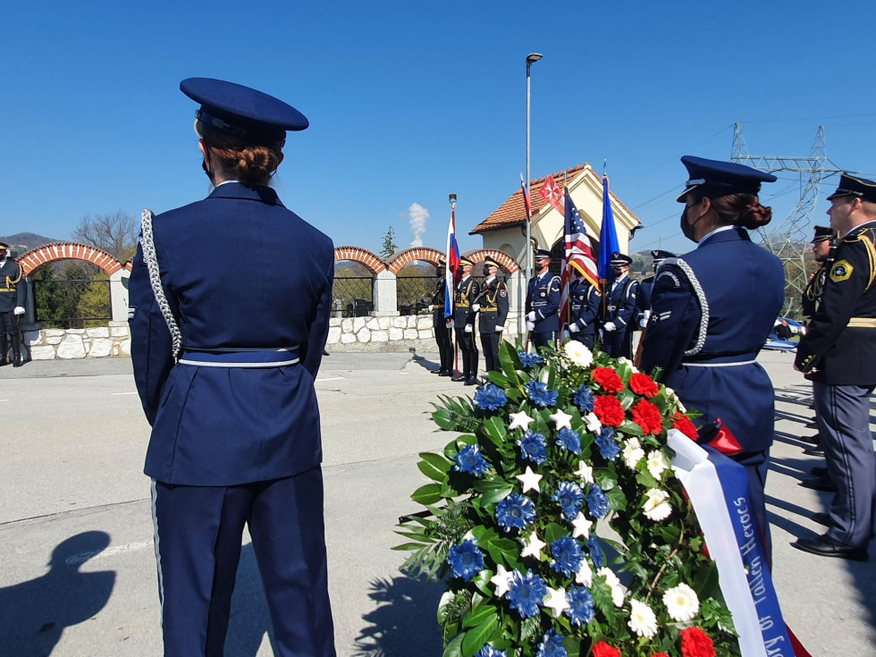 Ameriška vojaka stojita ob vencih položenih pred pomnik