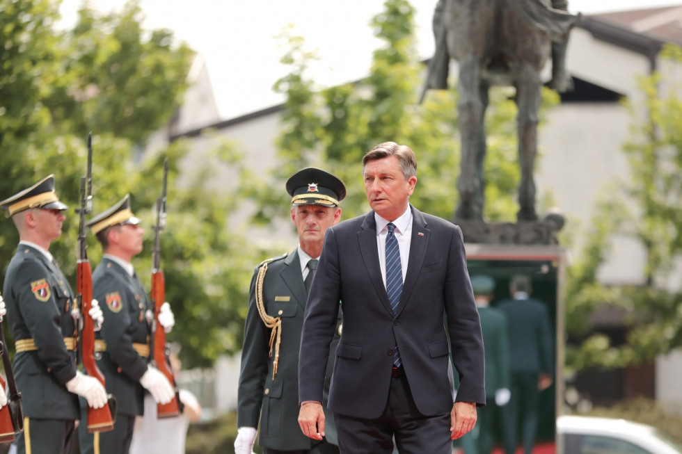 Predsednik v spremstvu adjutanta prihaja na ministrstvo. V ozadju sta gardista Slovenske vojske in kip Rudolfa Maistra