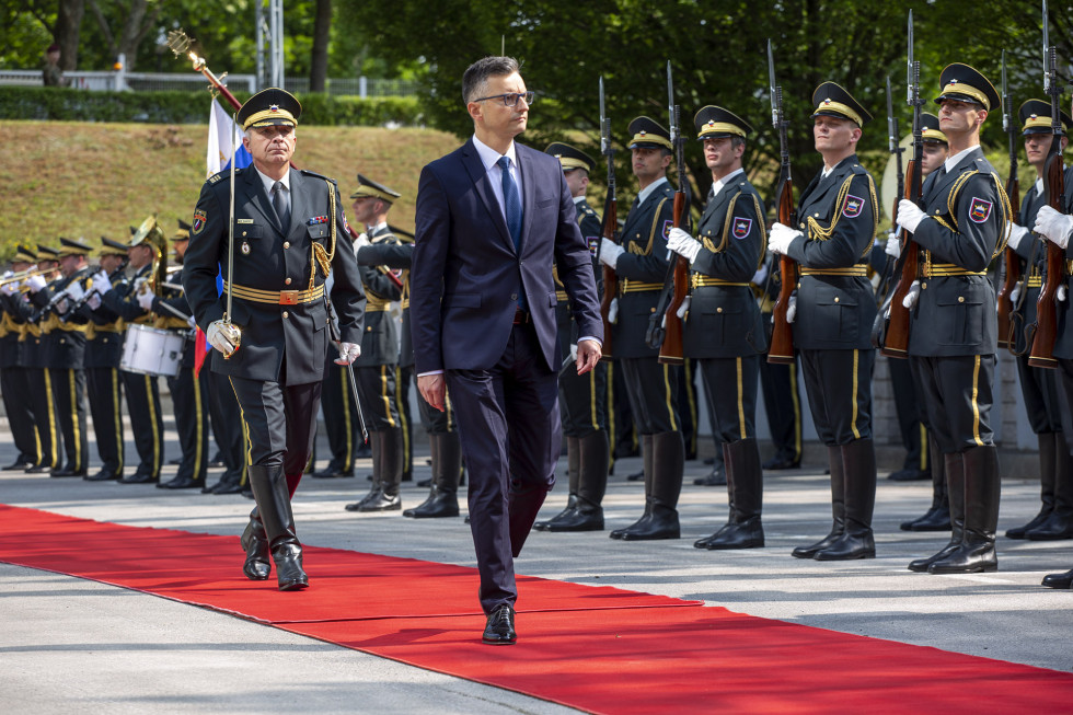 Minister hodi po rdeči preprogi in pregleduje postrojeno častno četo Slovenske vojske 