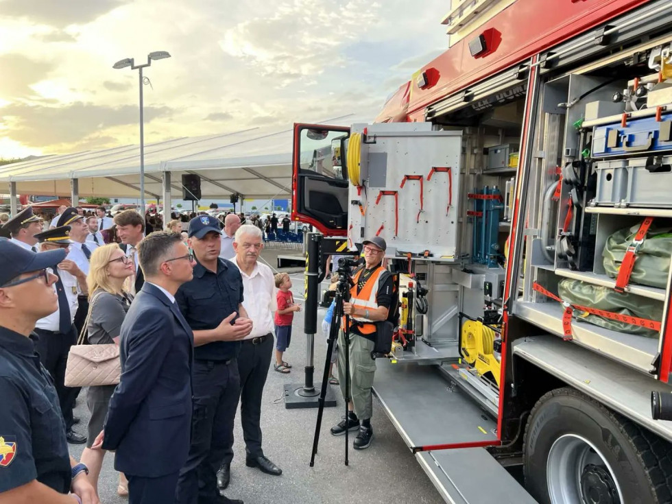 Minister in gasilci si ogeldujejo novo gasilsko reševalno vozilo