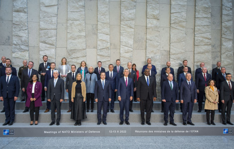 221013d 004 nato (Group photo of ministers. They are standing on low steps, with NATO flags and a high stone wall behind them.)
