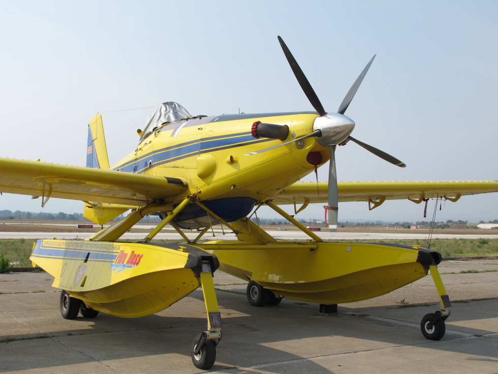Rumeno letalo za gašenje z velikima rezervoarjema na krilih stoji na letališki stezi