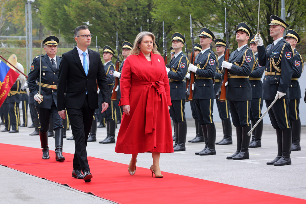 Ministra hodita drug ob drugem po rdeči preprogi in pregledujeta častno četo