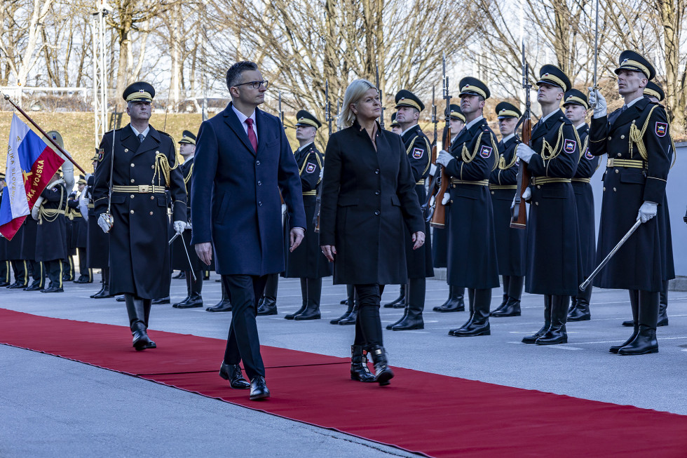 The two ministers walk the red carpet next to the line-up of the Slovenian Army's honor guard