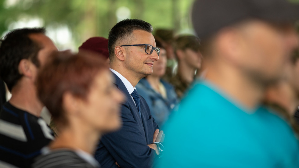 Portret ministra Šarca, ki stoji med udeleženci tabora in starši udeležencev..