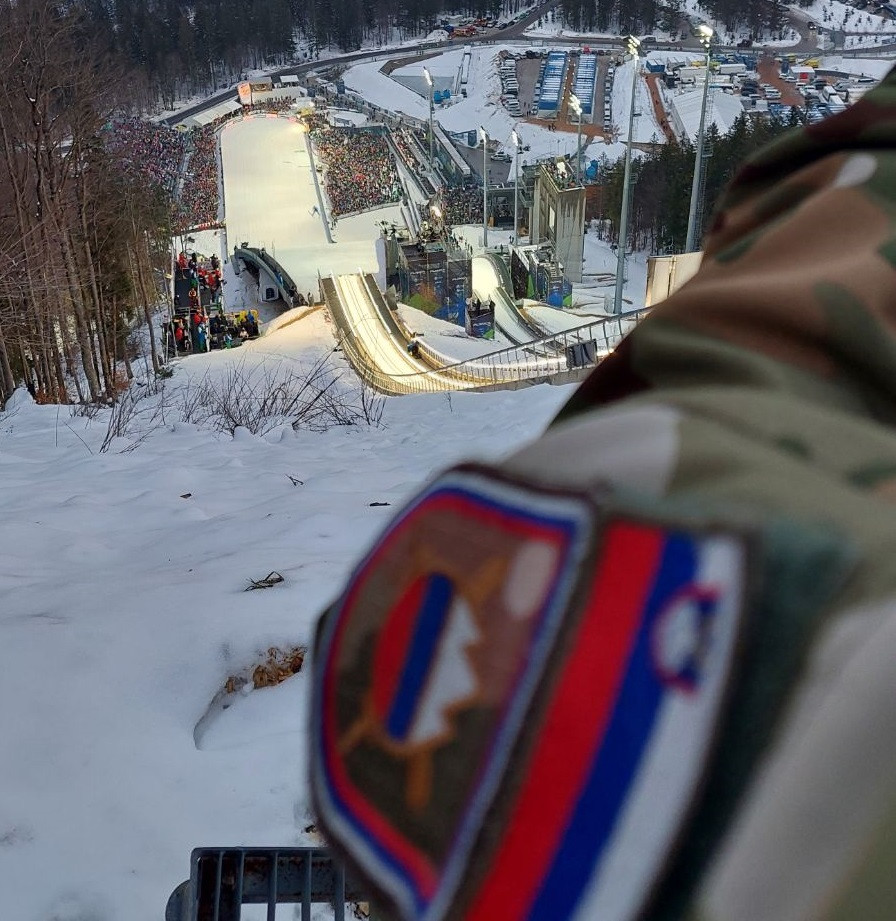 Oznaka Slovenske vojske na rokavu vojaka. V daljavi je letalnica v Planici