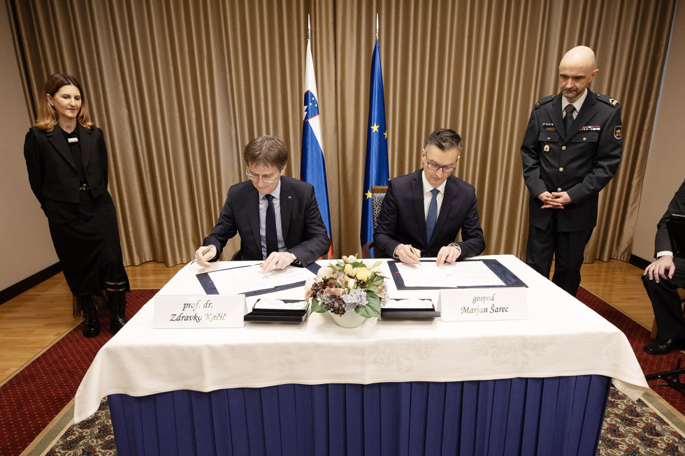 Minister Šarec in rektor mariborske univerze prof. dr. Kačič sedita za slavnostno mizo in podpisujeta sporazum