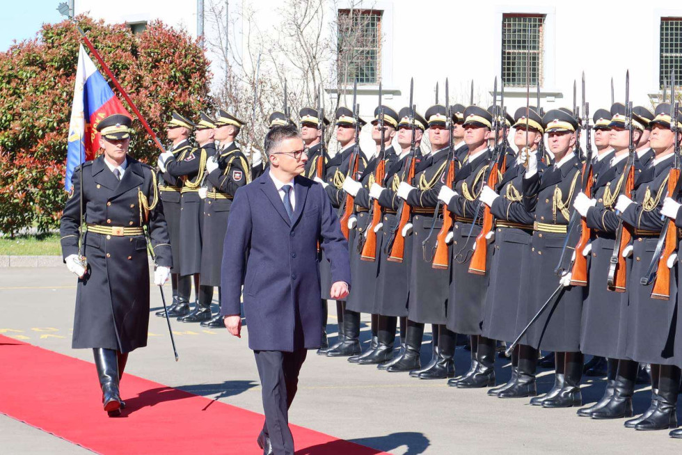 Minister hodi po rdeči preprogi in pregleduje postrojeno častno četo