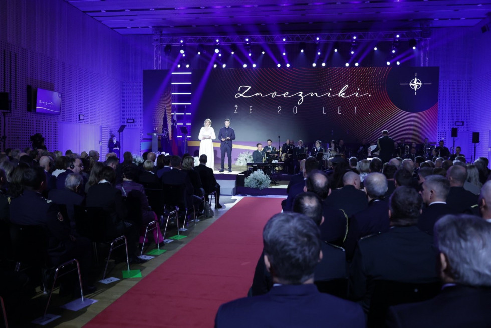 View of the stage with lighting, NATO logo billboard and audience in the auditorium