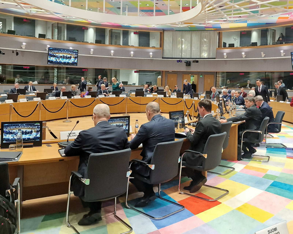 Razpravna ovalna dvorana z udeleženci zasedanja. Večina sedi za mizo in glega zaslone pred seboj, nekaj jih stoji.