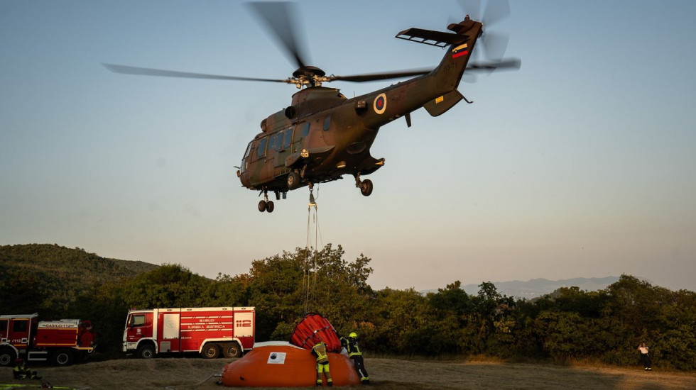 Helikopter Slovenske vojske zajema vodo iz napihljivega bazena