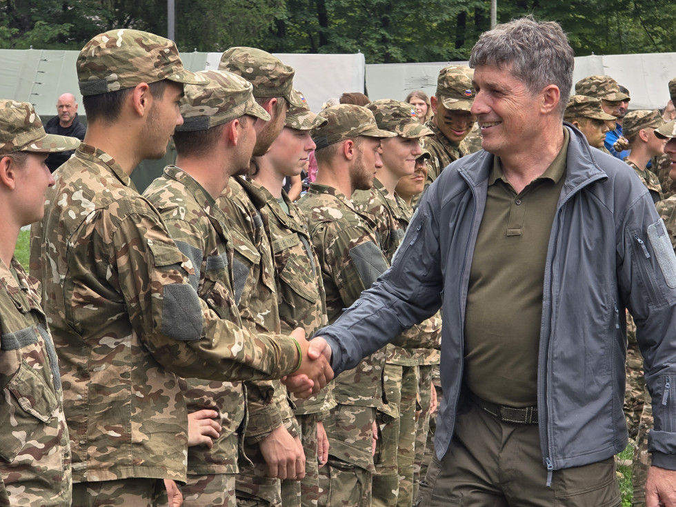Minister Sajovic se rokuje z mladimi udeleženci v vojaških uniformah, ki stojijo v postroju.