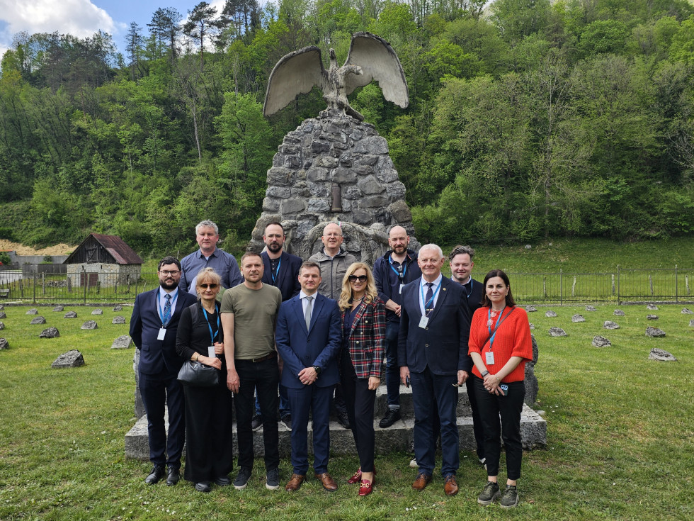 Skupinska fotografija udeležencev pred pomnikom na Poti miru