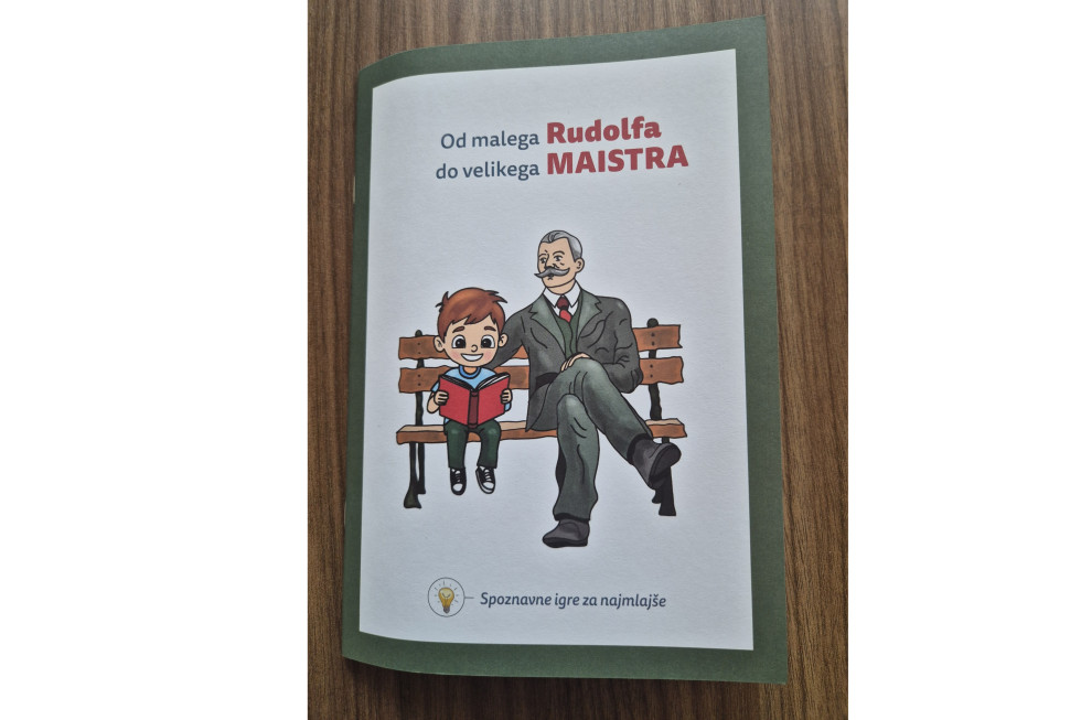 Pod naslovom sta naslikana otrok in starejši moški v podobi generala Maistra, ki sedita na leseni klopi. Deček drži v rokah odprto knjigo in si jo ogleduje z veselim izrazom na obrazu.