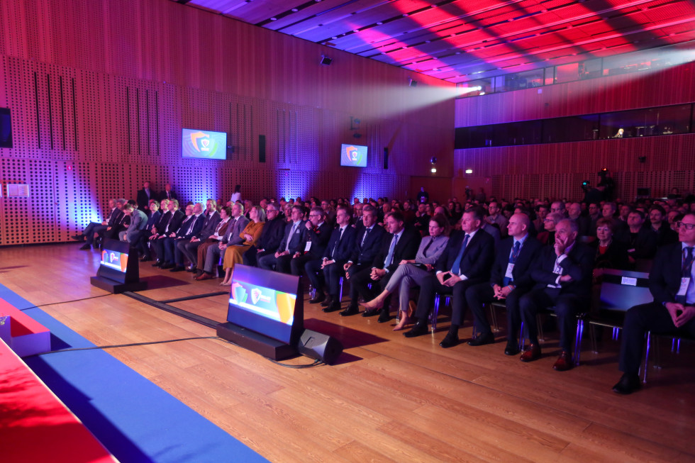 Udeleženci sedijo v dvorani konferenčnega centra Brdo