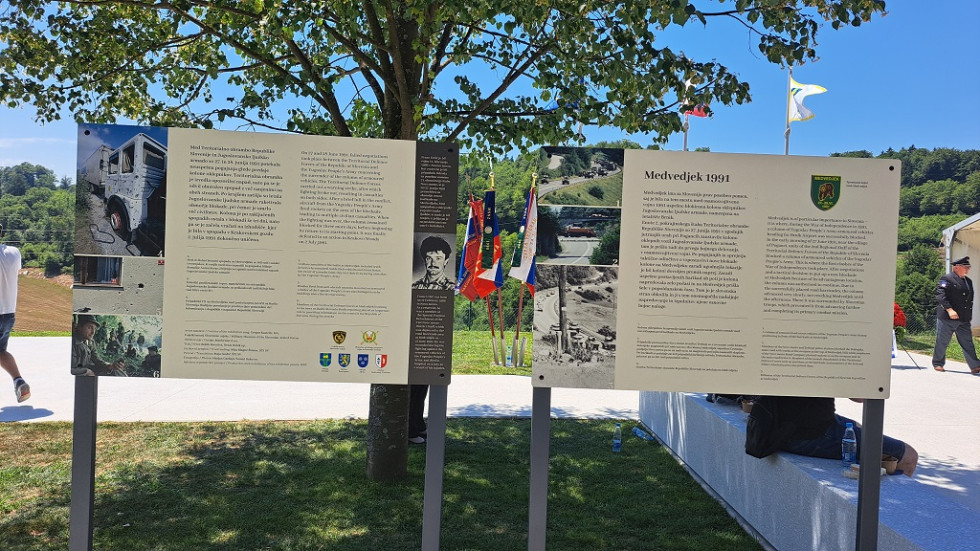 Razstavna panoja pred vhodom v spominski park Medvedjek