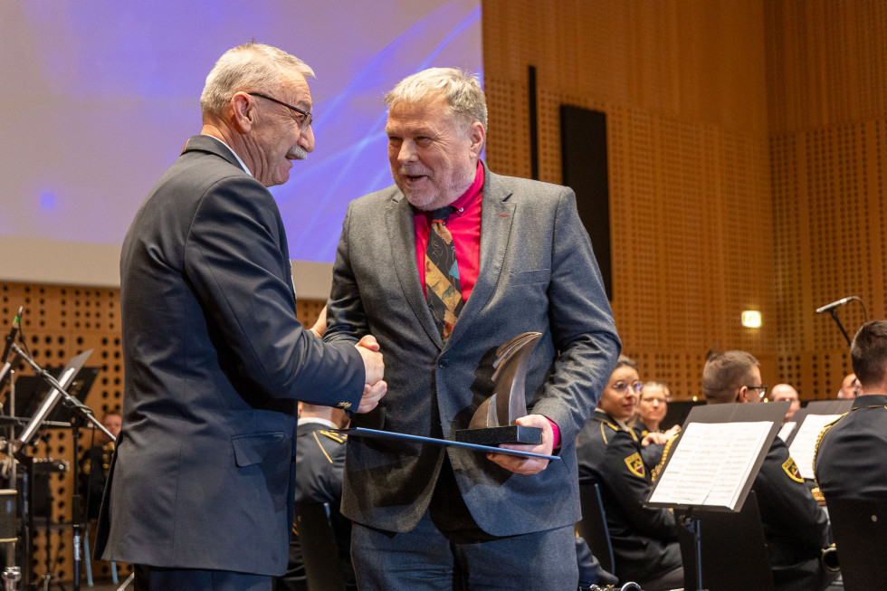 Prejemnik kipca Civilne zaščite ga prejema iz rok poveljnika Civilne zaščite 