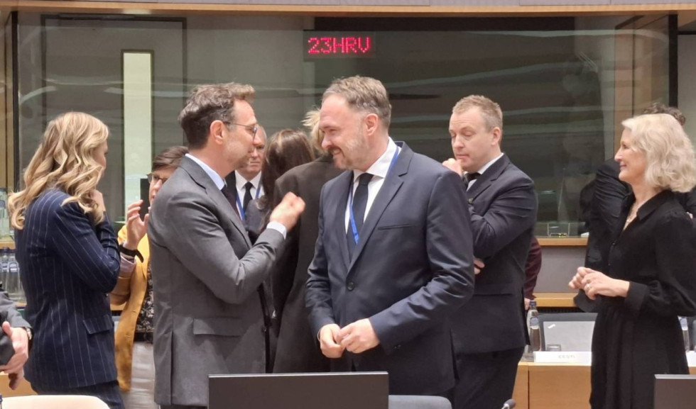 Državni sekretar se v skupini ljudi pogovarja z ostalimi udeleženci.