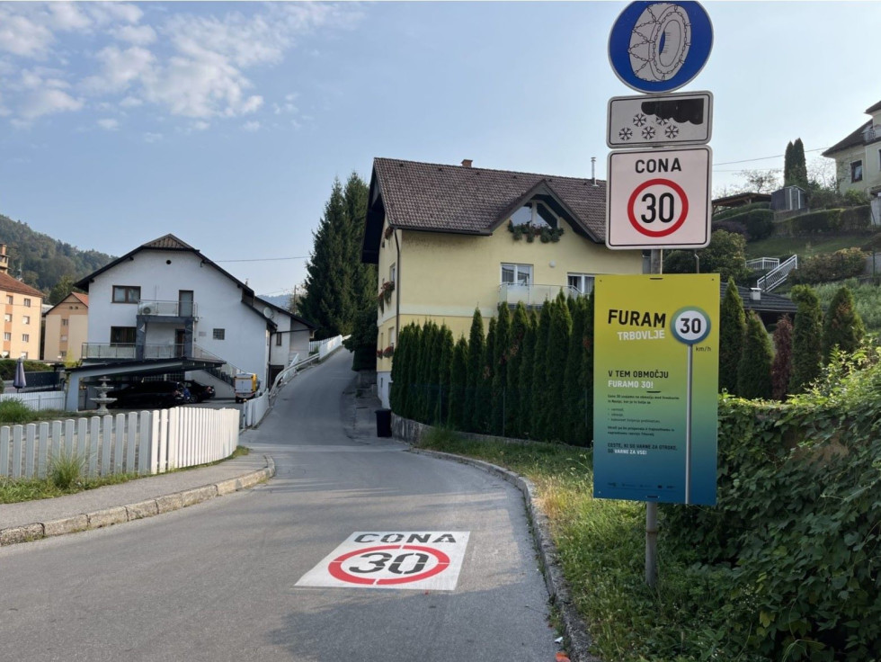 Prometni znak ob cesti in na tleh znak omejitev hitrosti 30 
