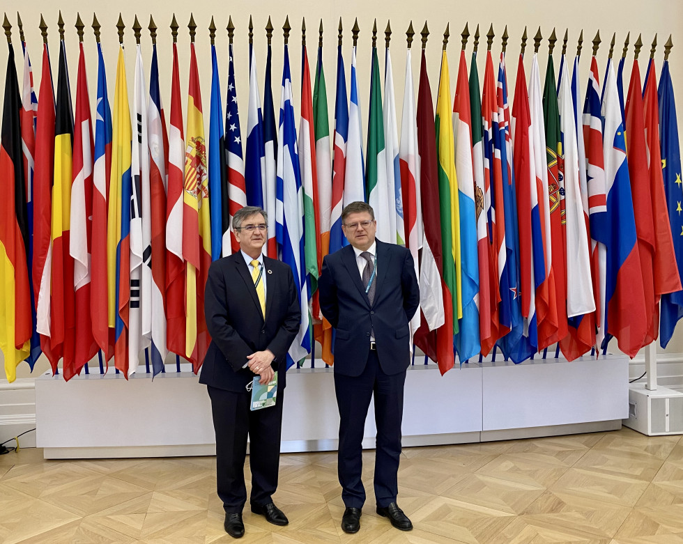 Veleposlanik Peter Ješovnik in direktor OECD za okolje Rodolfo Lacy stojita pred zastavami prisotnih držav