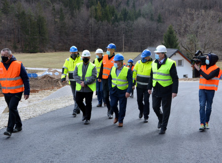 Udeleženci hodijo po cesti do gradbišča