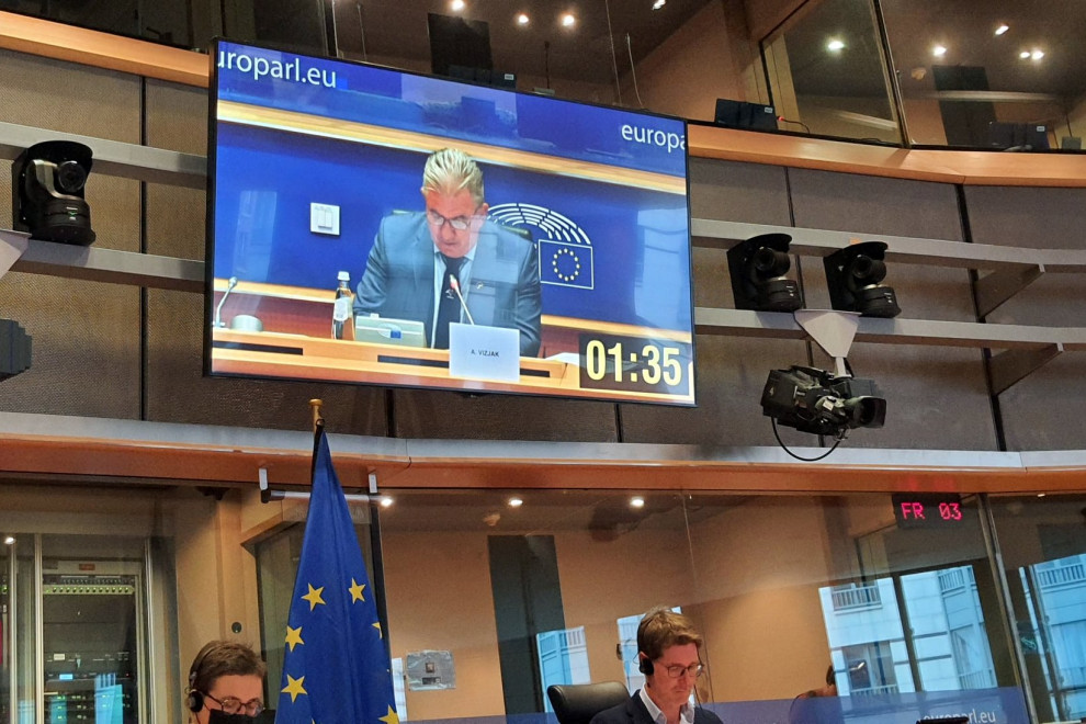 Fotografija velikega ekrana na katerem je prikaz ministra